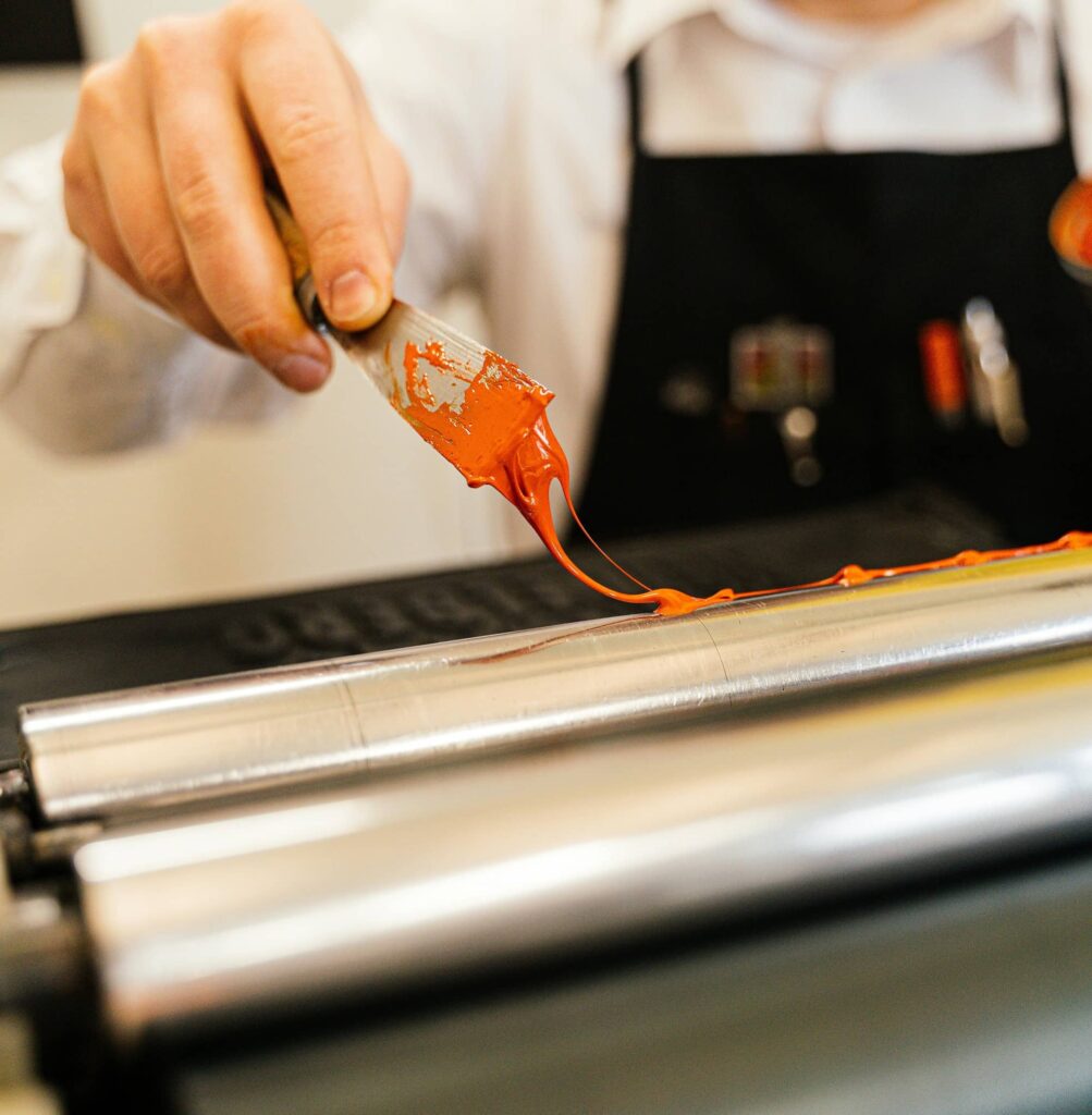 Ink rollers with an operator loading orange ink